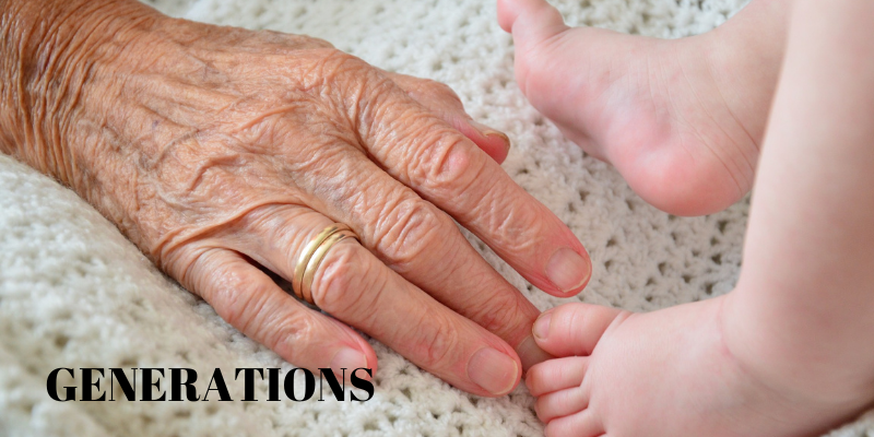 Picture of a hand of  an elderly person and the feet of a baby representing generations.