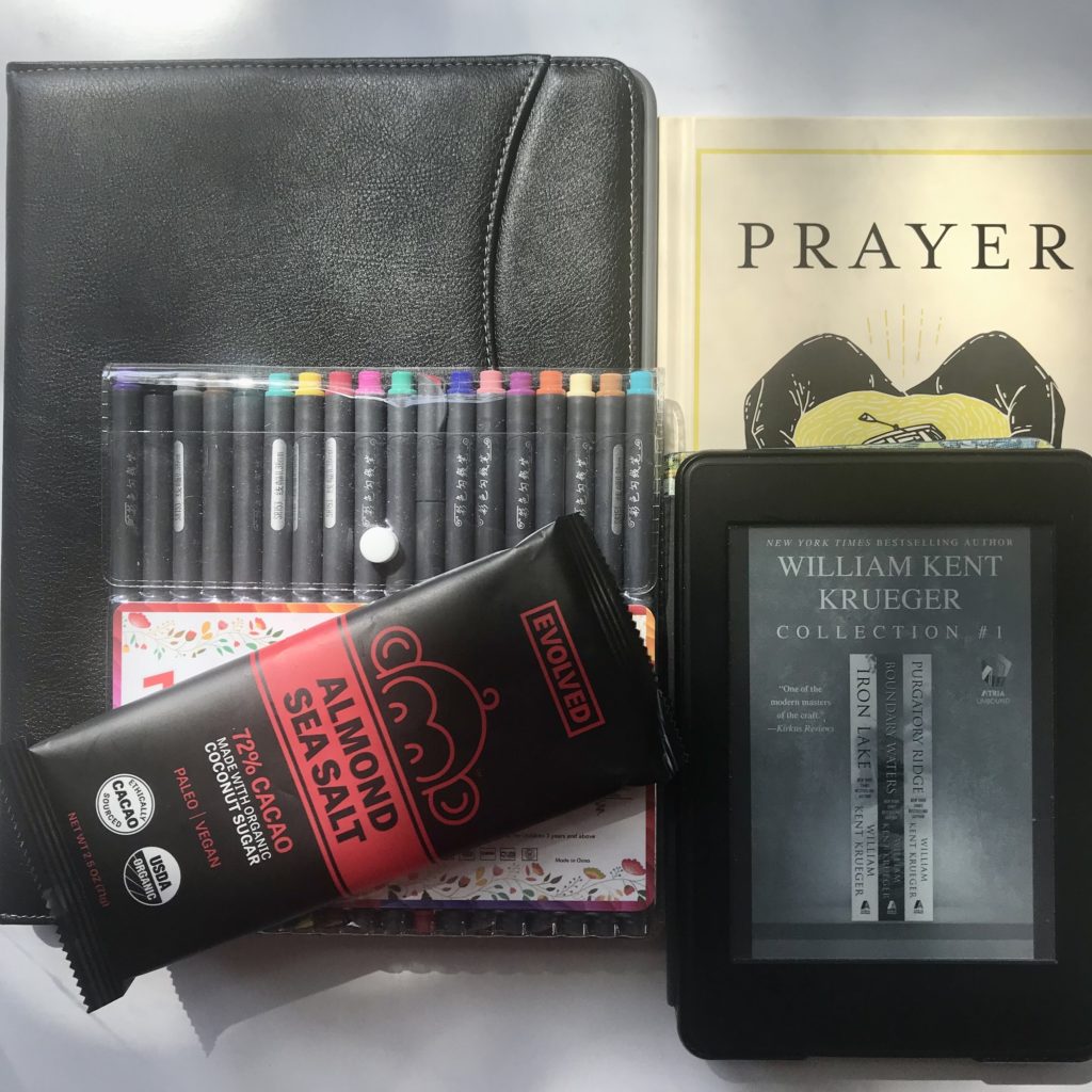 picture of back to school items, pens, Kindle, iPad, and chocolate