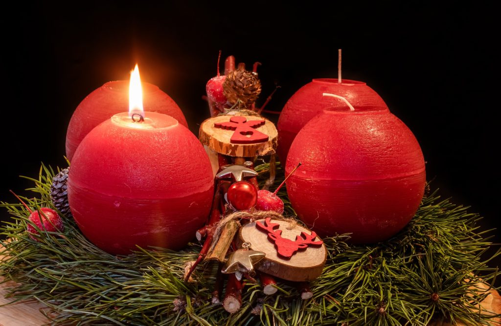 Image of four candles, the first one is lit representing week 1 of Advent, hope, wait on the Lord