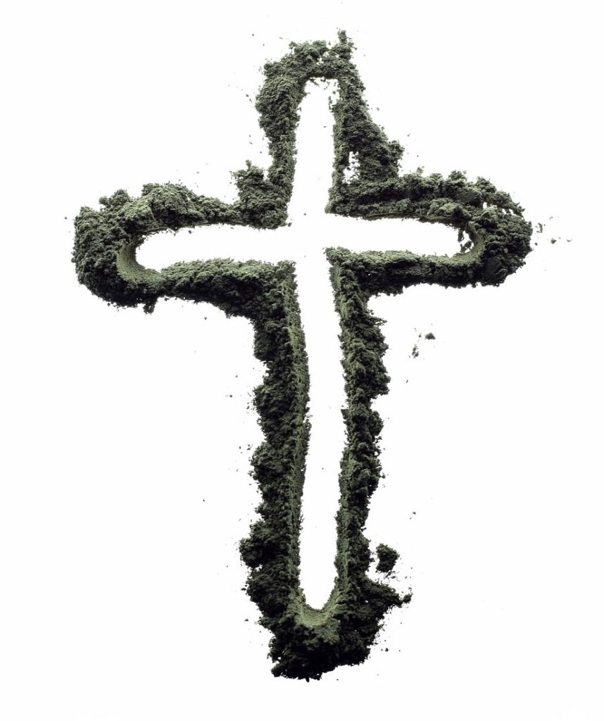 A cross outlined by ashes reflecting the Lenten season.