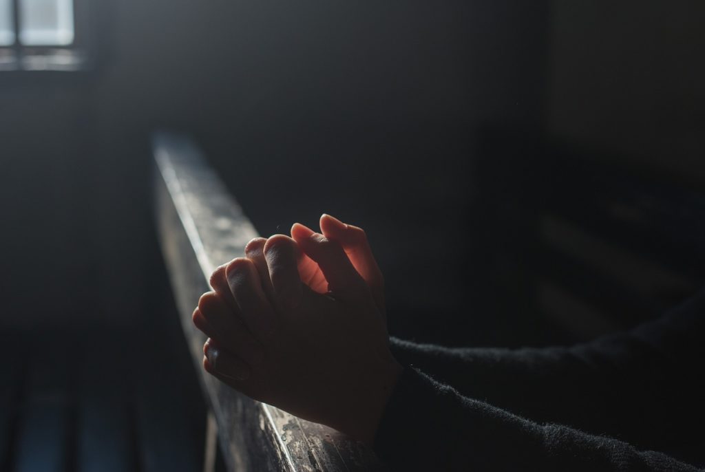 An altar, folded hands, illustrating prayer