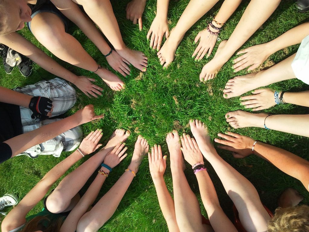 a picture of many hands and feet in a circle representing community